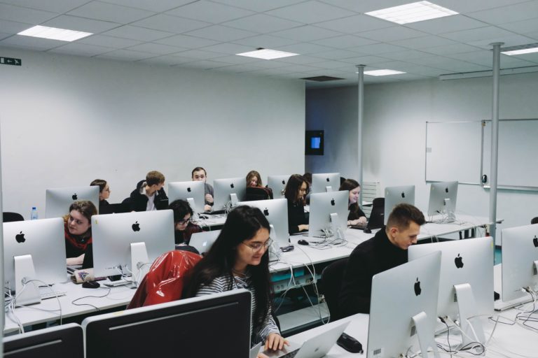 people sitting in front of monitors inside room