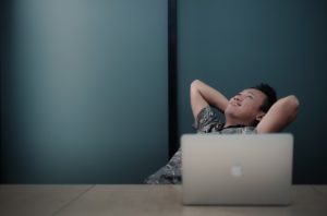 man sitting on chair front of white MacBook