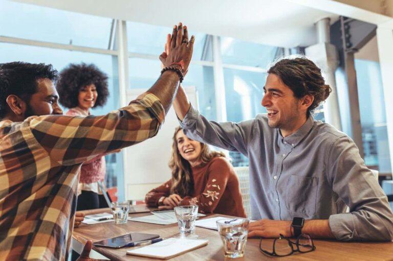 Glückliche Mitarbeiter im Büro | Retention Management, Bedeutung, Maßnahmen und Kosten