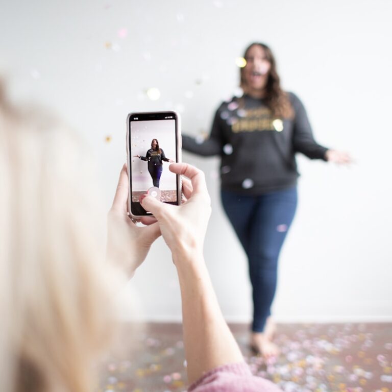 TikTok Karriereseiten - person holding white smartphone taking photo of woman wearing blue jeans
