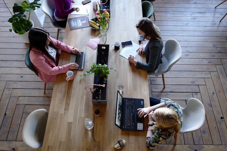 Recruiting-Pflichtprogramm - Three Woman Sitting on White Chair in Front of Table
